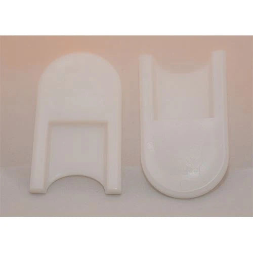 Two white U-shaped objects on a light pink background
