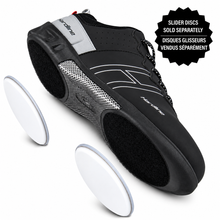 Load image into Gallery viewer, A black and gray curling shoe with white accents, shown alongside two separate white oval slider discs on a white background. A black text badge in the top right reads 'SLIDER DISCS SOLD SEPARATELY' with French text below.